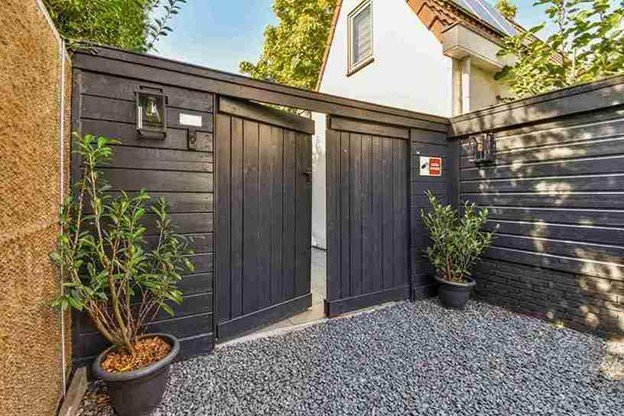 Modern residential driveway gate installed with an automatic gate opener system, showing clean alignment and secure entry.